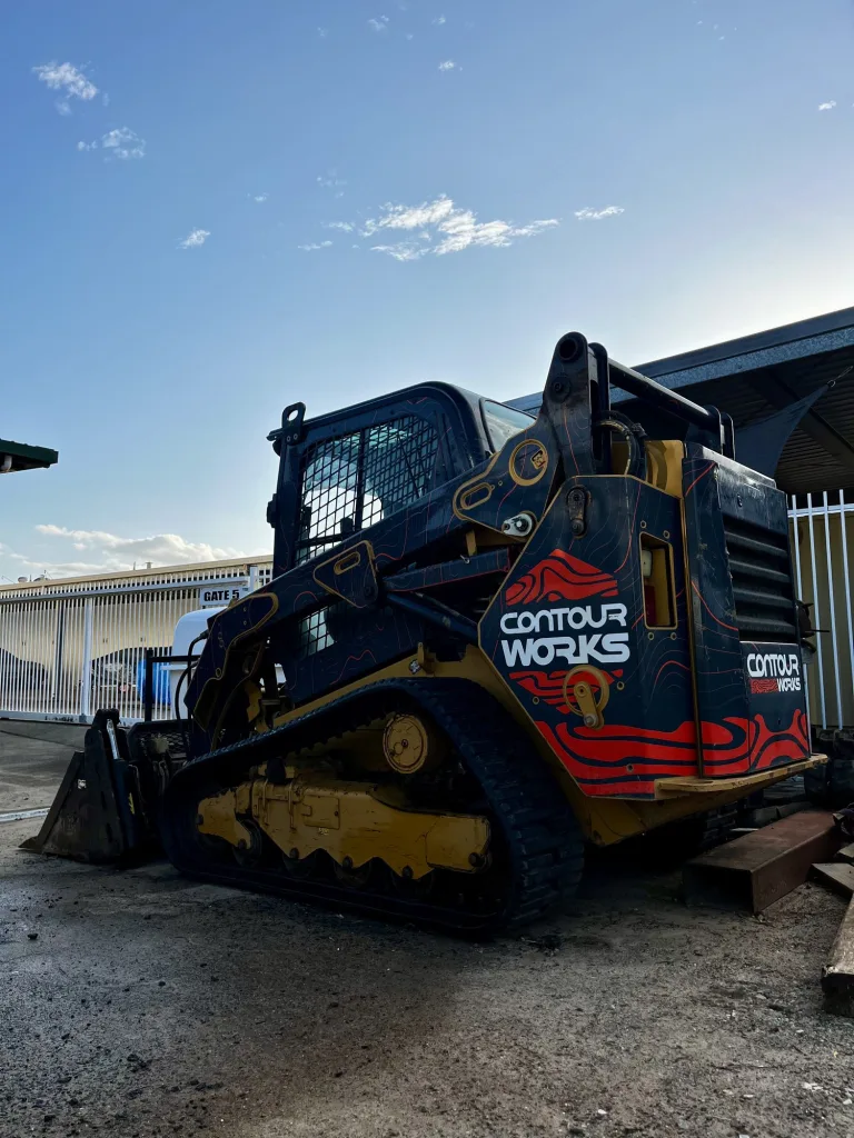 Contour Works branded tracked skid steer in the yard