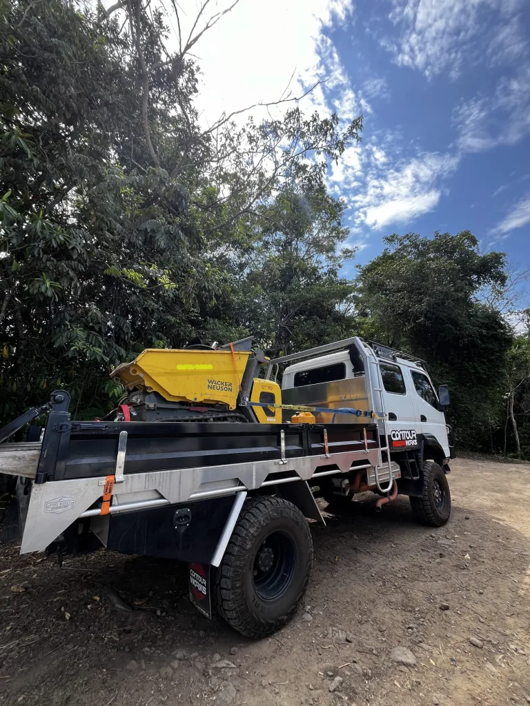 Mitsubishi Canter 4x4 tipper carrying a tracked dumper